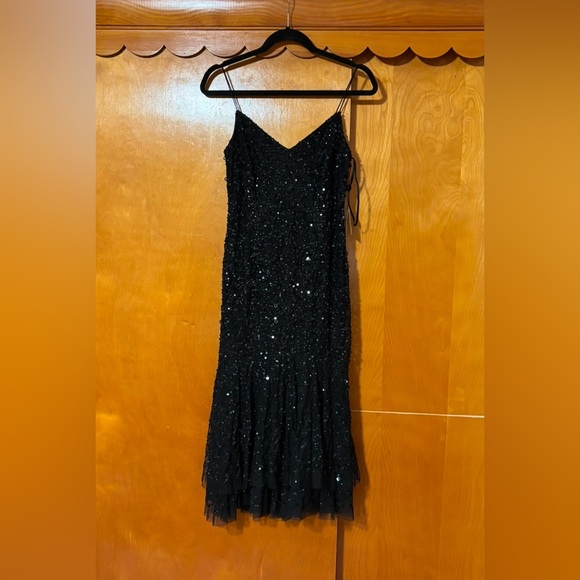 Shiny sequins and a sheer asymmetrical hem accentuate this sleeveless dress - Picture 2 of 6